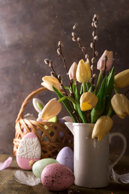 Tulipani della primavera con le uova di pasqua su fondo rustico