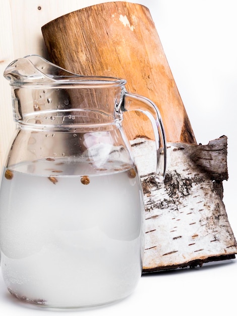 Весенний полезный витаминный напиток Свежий холодный березовый сок в кувшине с изюмом Концепция здорового и витаминного питания