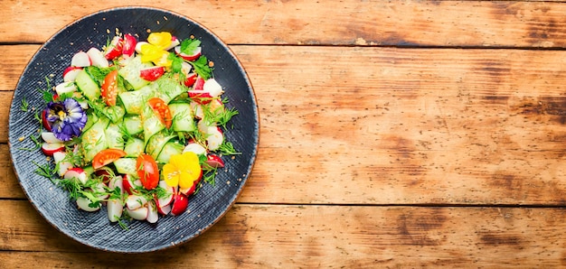 Spring vegetable salad with flowers,space for text