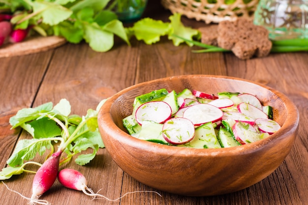 Spring vegetable salad in a wooden plate