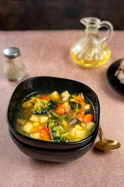 Spring vegetable soup in a black bowl