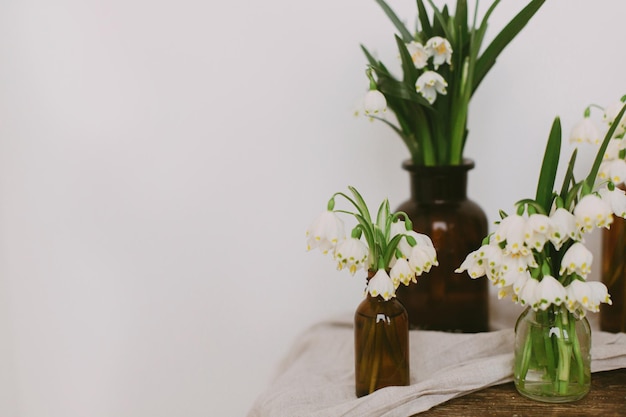 素朴な布と部屋の木材にレトロなガラス瓶に春の白い花 田舎の静物