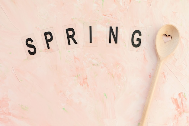 Photo spring word and stirring spoon on a pink