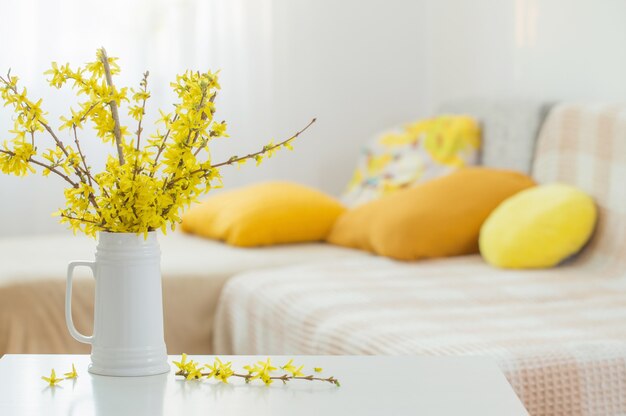 Spring yellow flowers in vase on modern interior