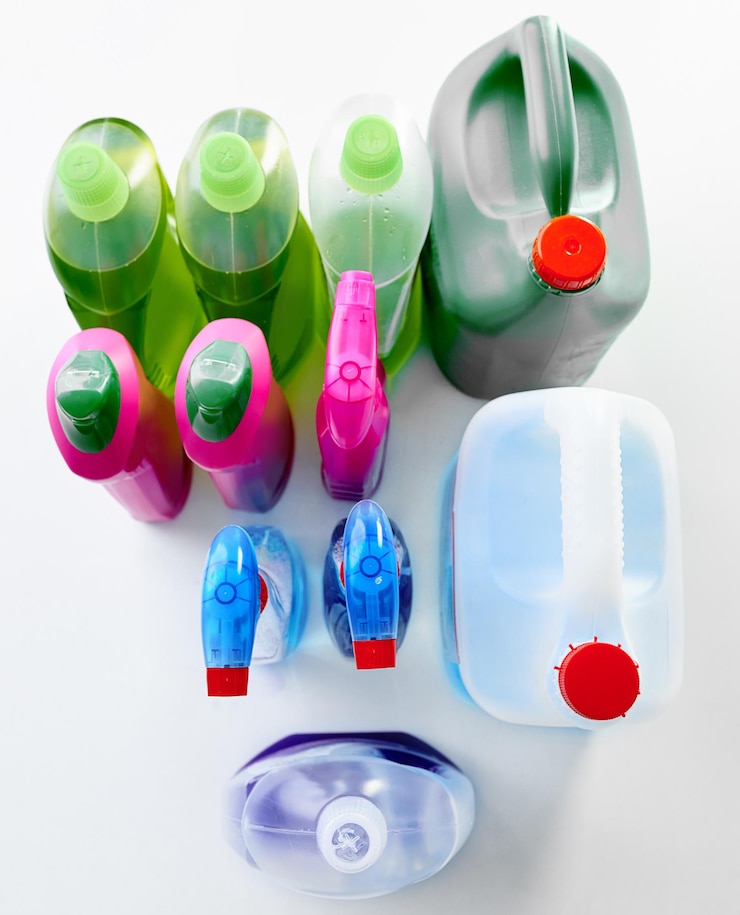 Foto springcleaning essentials studio shot van verschillende flessen wasmiddel tegen een grijze achtergrond