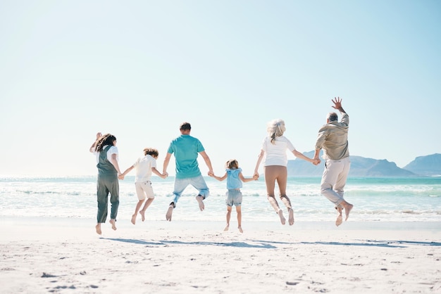 Springen reizen en hand in hand met grote familie op het strand voor steun zomervakantie of binding Vrijheid gezondheid en liefde met mensen op zee vakantie voor avontuur vertrouwen of geluk samen