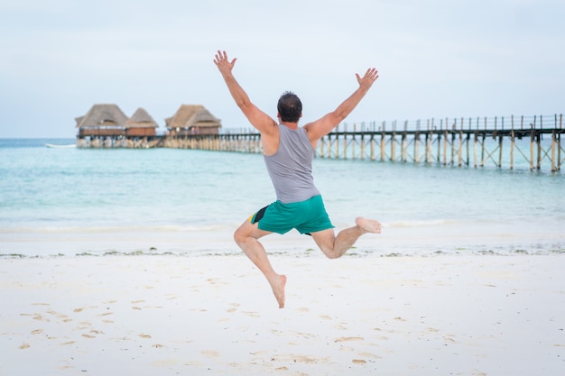 Springende mens op tropisch strand