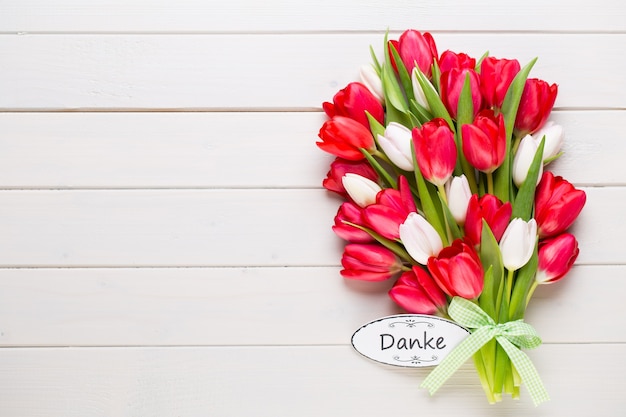 Springt time. Red tulip bouquet on the white wooden background.