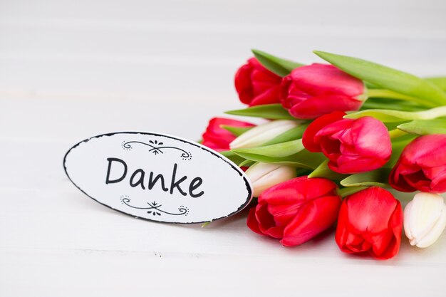 Springt time. Red tulip bouquet on the white wooden background.