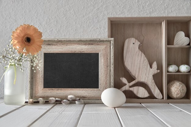 Photo springtime background: blackboard, display cabinet with easter decorations and yellow gerbera, text