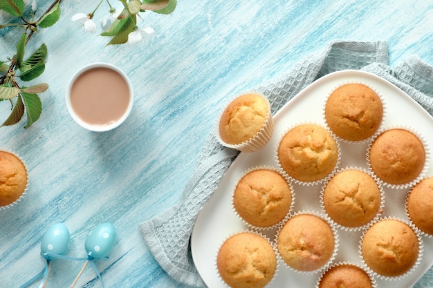 Springtime or Easter flat lay with plate of lemon muffins and marzipan eggs