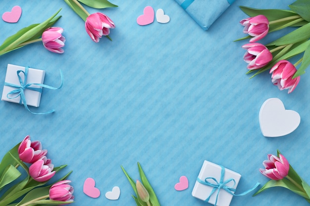 Springtime flat lay with giift boxes, pink tulips and decorative hearts, copy-space