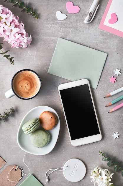 Springtime flat lay with pearl hyacinth flowers, eucalyptus, mobile phone and gift postcards