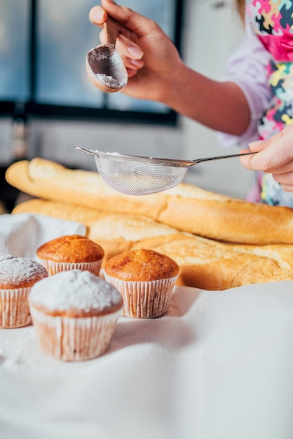 Foto sprinkle cupcakes met suikerpoeder door een sift