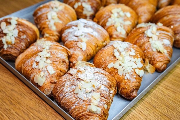 Sprinkle the finished croissants on a baking sheet with almond flakes