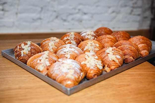 Sprinkle the finished croissants on a baking sheet with almond flakes