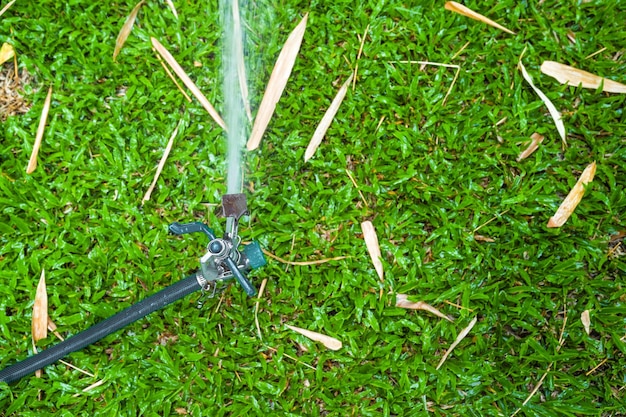 Photo sprinkle splashing water on grass