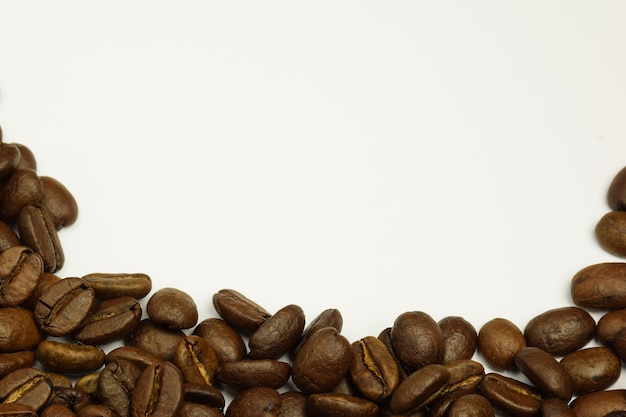 Sprinkled coffee beans at the bottom of the photo on a white background