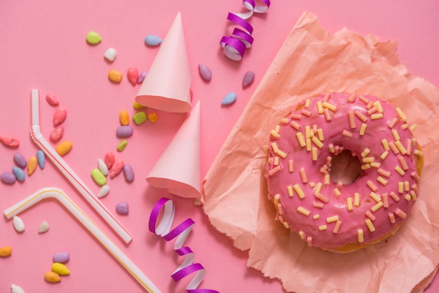 Sprinkled Pink Donut. Frosted sprinkled donut on pink background.