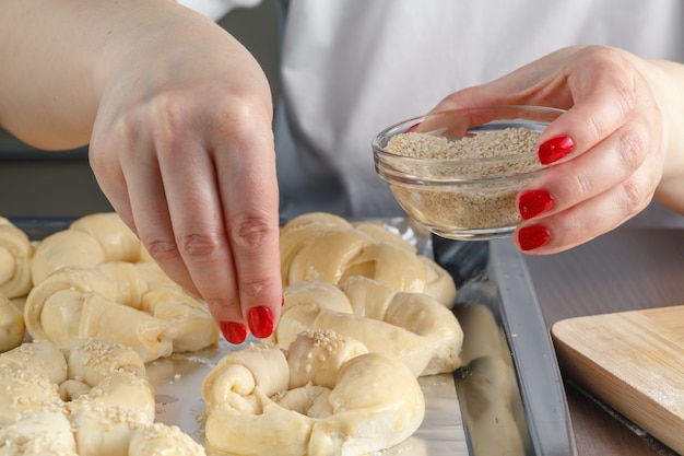 Sprinkling sesame seeds over homemade bagels