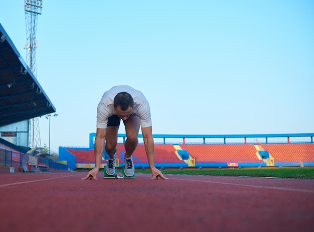 Sprinter die startblokken op de atletiekbaan verlaat. Explosief begin.