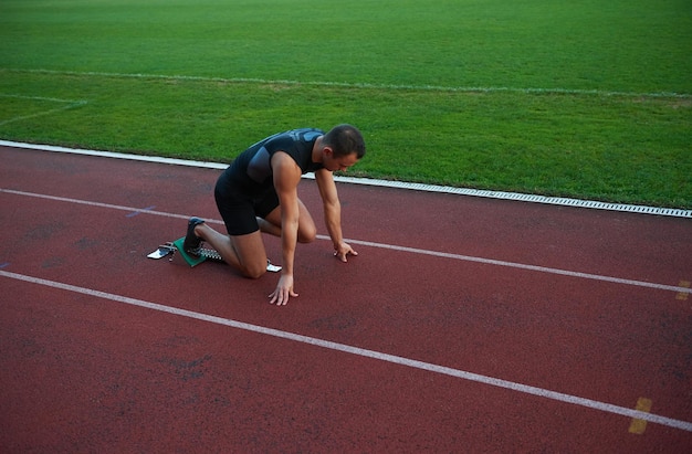 Sprinter leaving starting blocks on the running track. Explosive start.