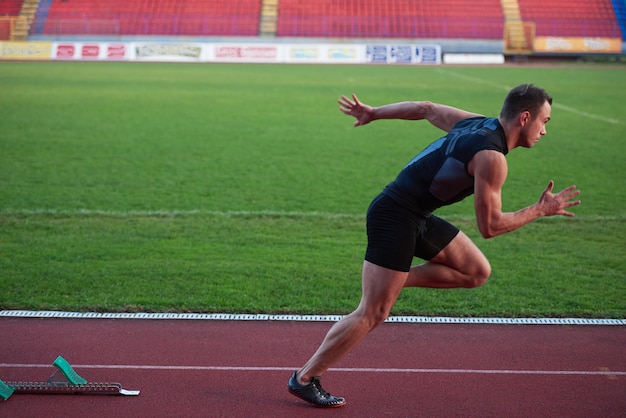 Sprinter leaving starting blocks on the running track. Explosive start.