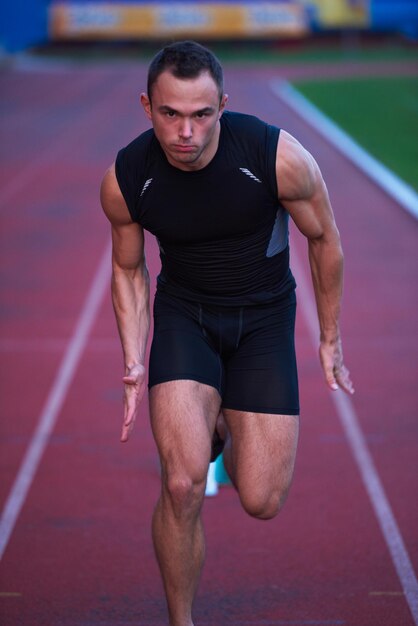 Sprinter leaving starting blocks on the running track. Explosive start.