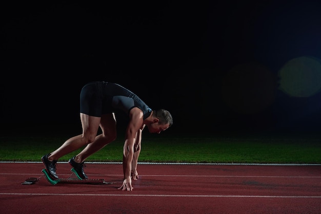 Sprinter leaving starting blocks on the running track. Explosive start.