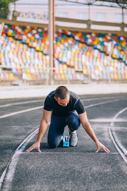 Sprinter leaving starting blocks on the running track. Explosive start.