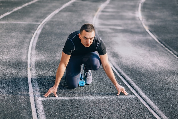 Sprinter verlaten van startblokken op de renbaan. Explosieve start.