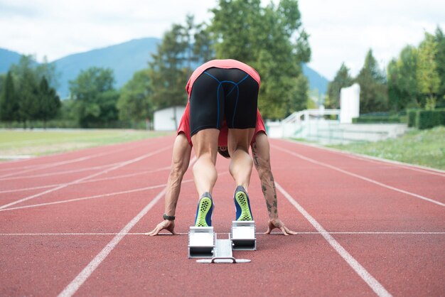 Sprinter verlaten van startblokken op de renbaan