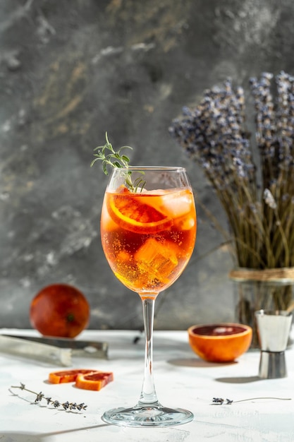 Foto spritz cocktail aperol tropicale con arance sanguinolente rosso amaro vino bianco secco scorza di soda e ghiaccio bevanda estiva