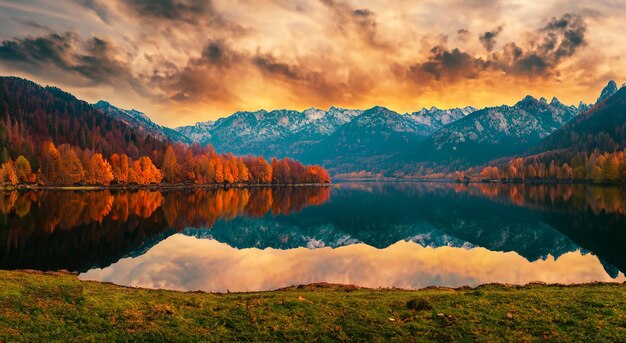 Sprookjesachtig landschap met een meer in de herfst en een prachtige zonsondergang