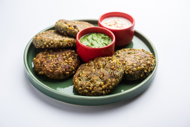 Sprouted moong dal tikki or patties is a healthy snack from India served with green chutney and curd