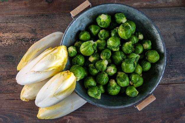 Sprouts and endives on wooden surface