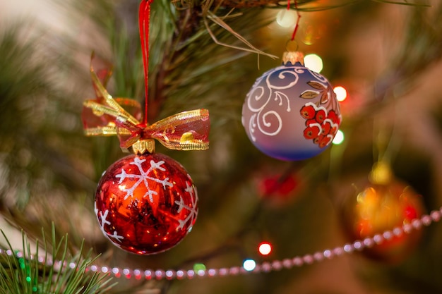 Spruce branch with Christmas balls and festive lights on the background