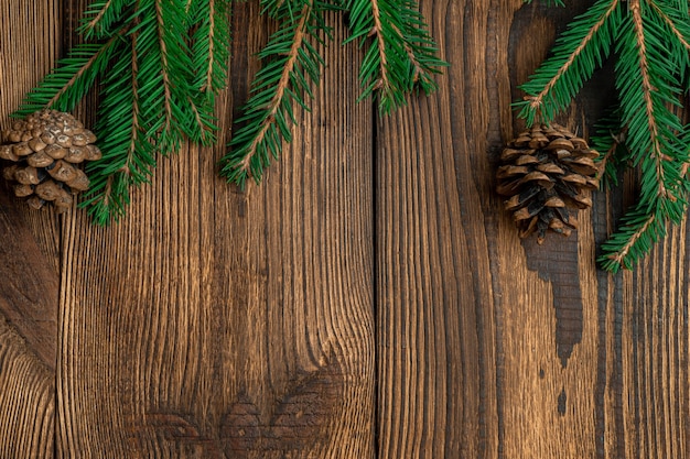 spruce branches on brown wooden table with copy space