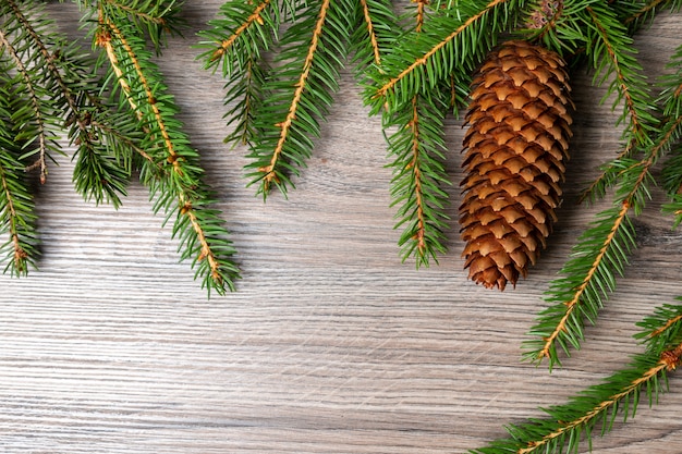 Spruce cone and spruce branches on wooden table