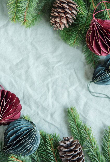 Spruce twigs and paper Christmas  decorations on the green linen crumpled textile background