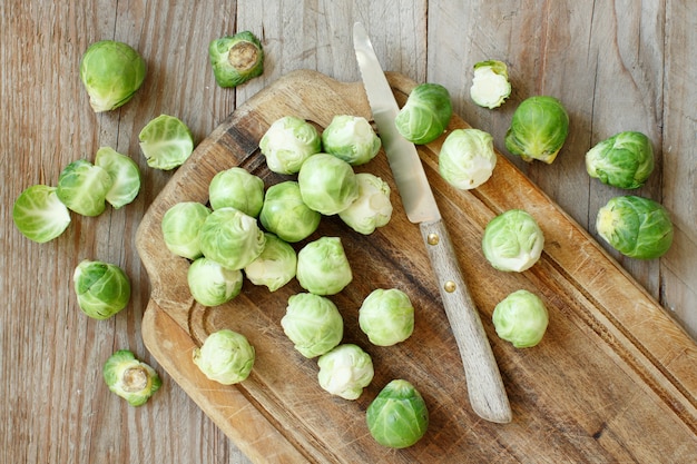 Spruitjes op een houten bord met een mes