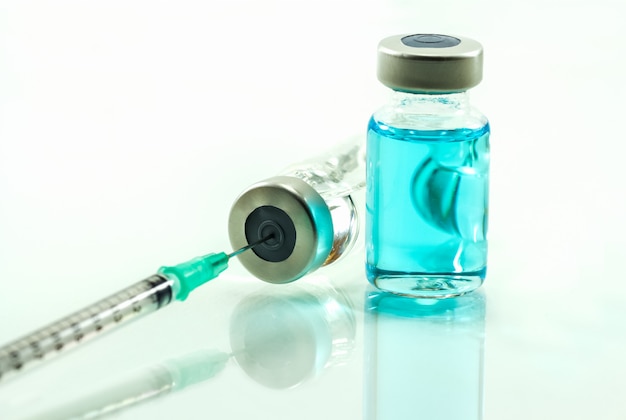 Spuit en vaccin op witte geïsoleerde achtergrond