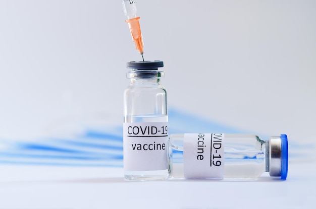 spuit met medische maskers en vaccinflacon glazen flessen voor vaccinatie. COVID-19. Coronavirus