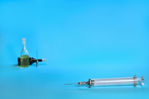 Foto spuit voor vaccinatie achter zijn ampullen met oplossing en een vervangbare naald
