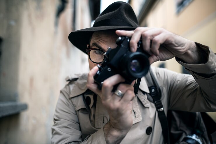 Photo spy or paparazzo photographer, man using camera in a city street