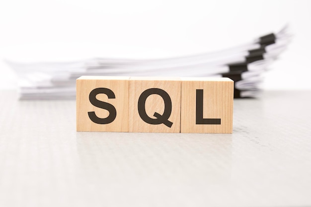 木製立方体の SQL 文字の背景は白いビジネス ペーパーの財務コンセプトです