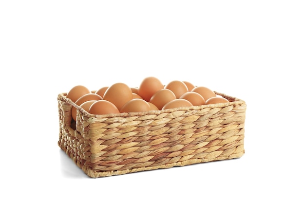 Square basket with brown eggs on white background