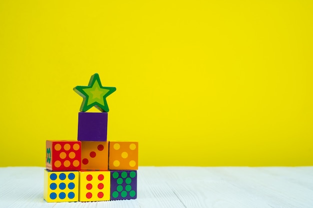 Square block puzzle toy on table with yellow