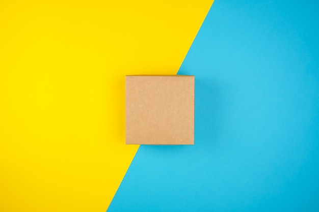 Square brown gift box on a yellow-blue background