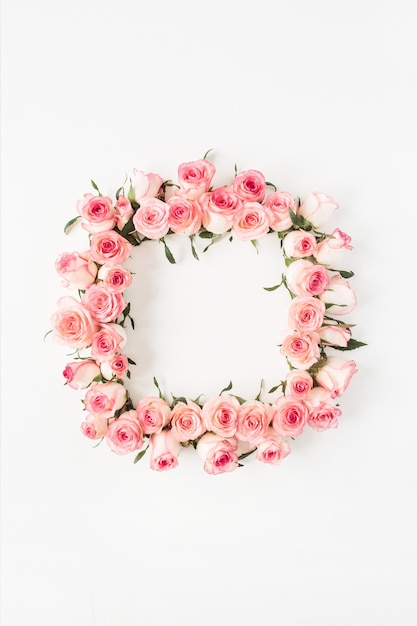 Photo square frame border of pink rose flower buds on white surface